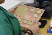 Técnico examina uma placa de circuito impresso em um laboratório moderno de eletrônica