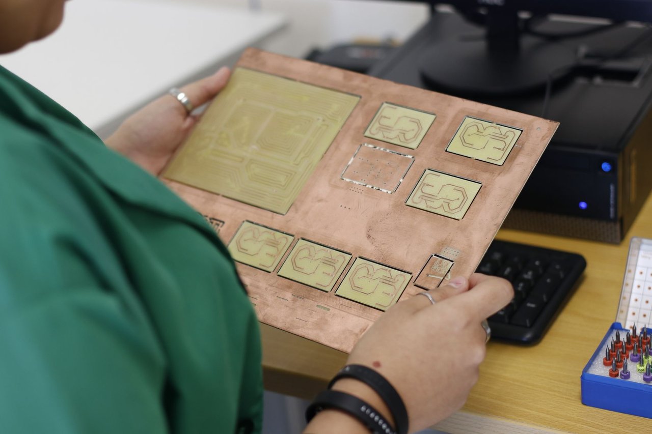 Técnico examina uma placa de circuito impresso em um laboratório moderno de eletrônica