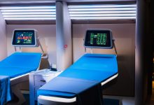 Quarto hospitalar moderno equipado com aparelhos médicos e telas digitais.