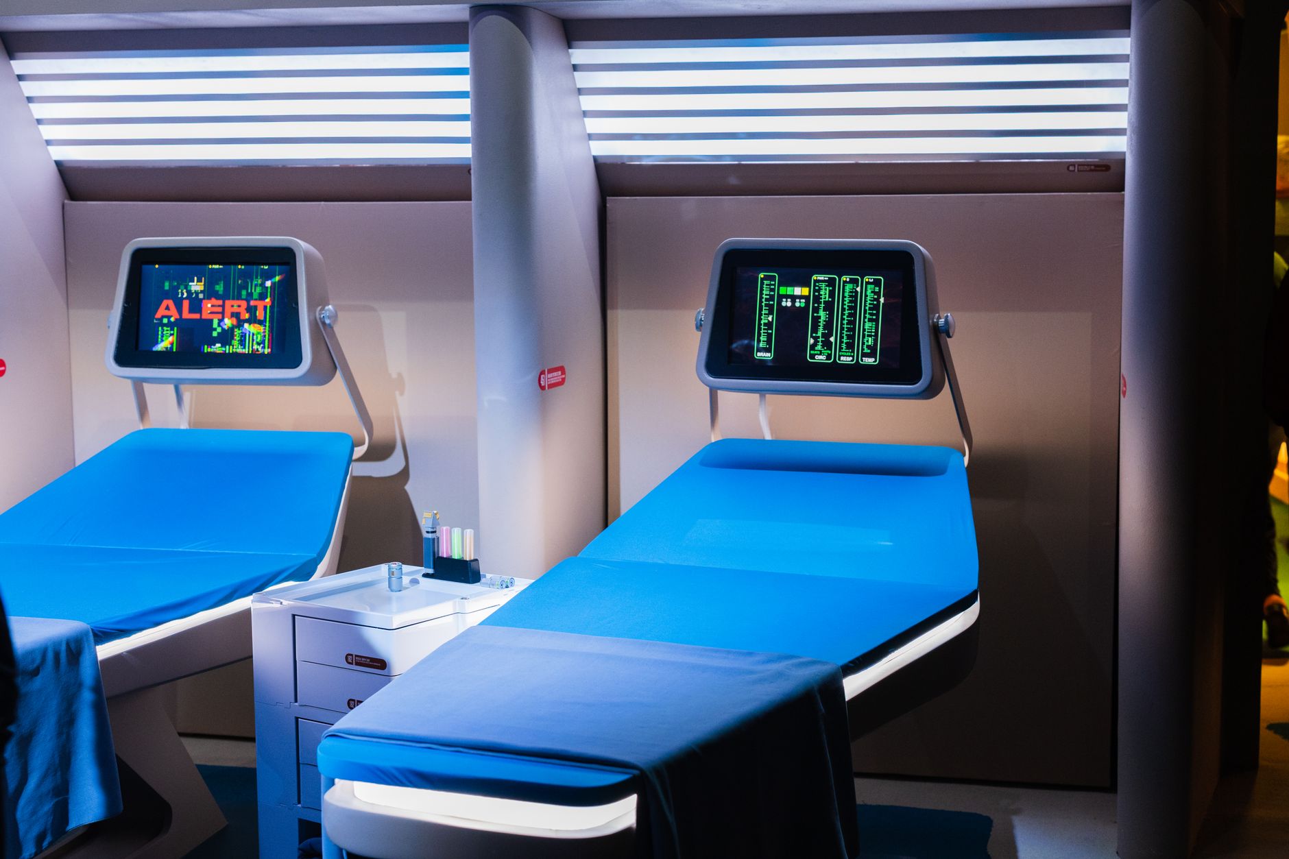 Quarto hospitalar moderno equipado com aparelhos médicos e telas digitais.