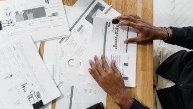 Profissional analisa documentos financeiros sobre uma mesa de trabalho.